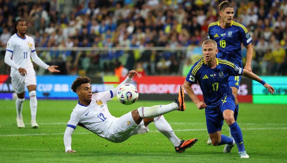 Дезире Дуэ не дает Александру Зинченко потрогать мяч. Фото: Reuters