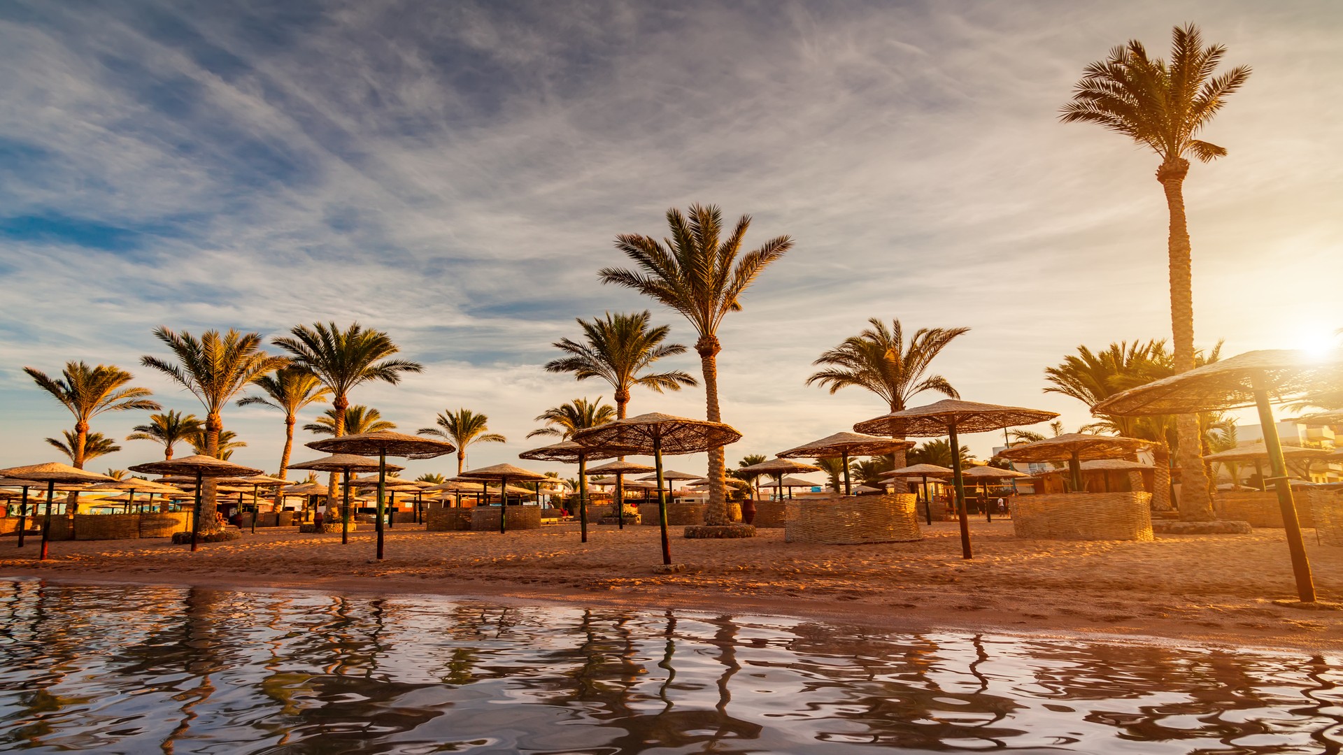 Прекрасный романтический закат над песчаным пляжем и пальмами, Хургада.