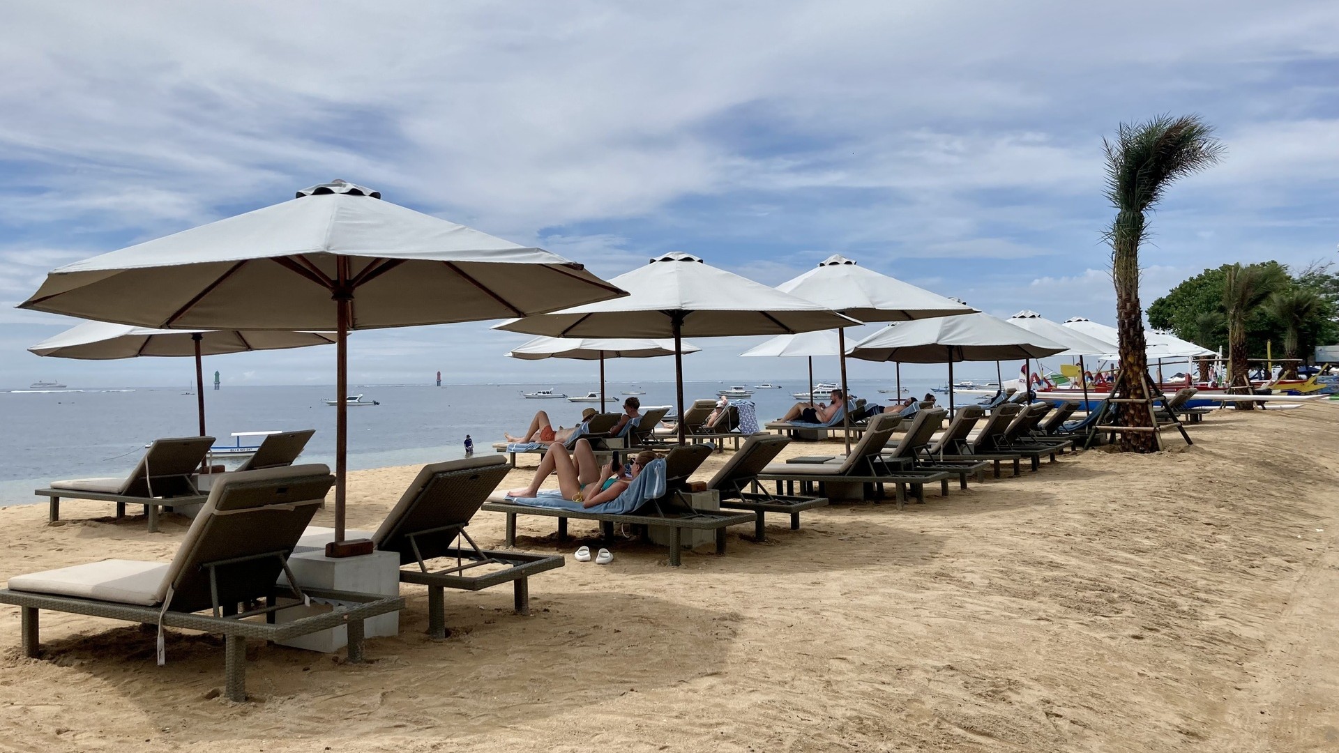 Люди отдыхают на пляже Санур, Бали.